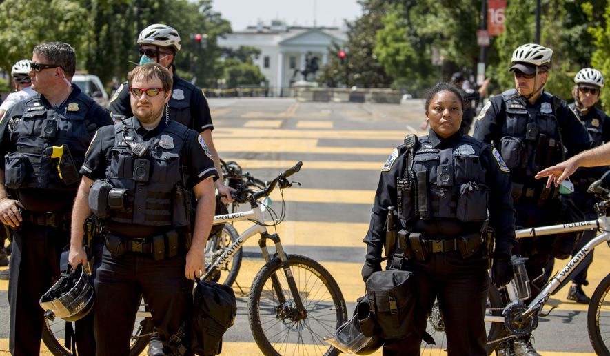The White House is visible as a line of police officers close 16th Street Northwest between H and I Street renamed Black Lives Matter Plaza, Tuesday, June 23, 2020, in Washington. (AP Photo/Andrew Harnik)