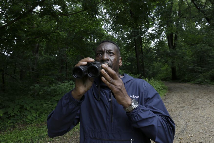 Keith Russell, program manager of urban conservation at Audubon Pennsylvania, lowers his binoculars while conducting a breeding bird census, at Wissahickon Valley Park Friday, June 5, 2020 in Philadelphia. (The viral video of a white woman targeting a Black bird watcher in New York's Central Park has renewed attention to how the great outdoors can often be far from great for Black people. (AP Photo/Jacqueline Larma)