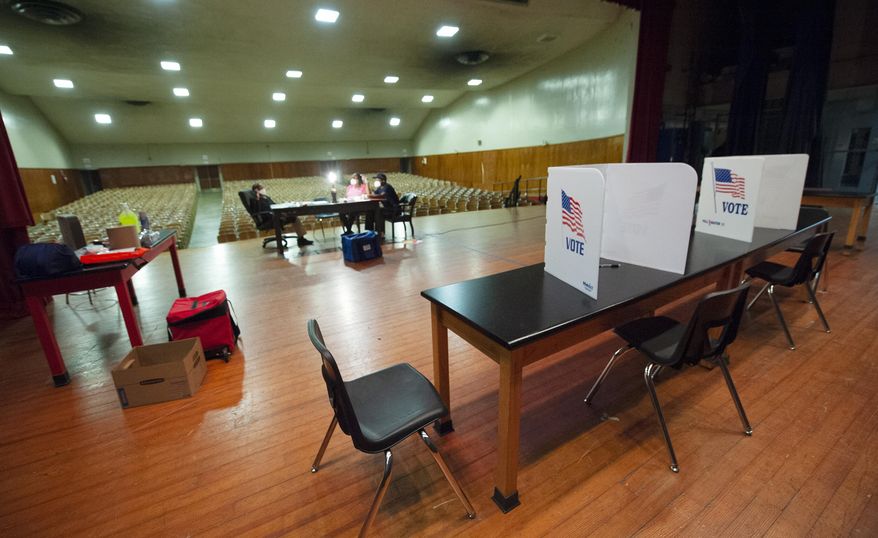 Poll workers try to pass the time during a long morning with no voters up to this point at precinct 38 at Chastain Middle School in Jackson, Miss., Tuesday, June 23, 2020, during the GOP nominee runoff election between Brian Flowers and Thomas Carey for the District 2 Congressional seat. The winner will advance to the November general election to face Democratic U.S. Rep. Bennie Thompson. (Barbara Gauntt/The Clarion-Ledger via AP)