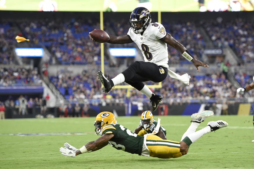  In this Aug. 15, 2019, file photo, Baltimore Ravens quarterback Lamar Jackson (8) leaps over Green Bay Packers cornerback Jaire Alexander (23) during the first half of a NFL football preseason game, in Baltimore. Ravens offensive coordinator Greg Roman is tweaking and refining a record-setting unit led by NFL MVP Lamar Jackson, who is expected to again be the key component of an attack with several newcomers in the mix.  (AP Photo/Gail Burton, File)  **FILE**