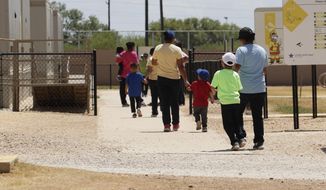 In this Aug. 23, 2019, file photo, immigrants seeking asylum hold hands as they leave a cafeteria at the ICE South Texas Family Residential Center in Dilley, Texas. (AP Photo/Eric Gay, File) ** FILE **