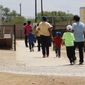 In this Aug. 23, 2019, file photo, immigrants seeking asylum hold hands as they leave a cafeteria at the ICE South Texas Family Residential Center in Dilley, Texas. (AP Photo/Eric Gay, File) ** FILE **