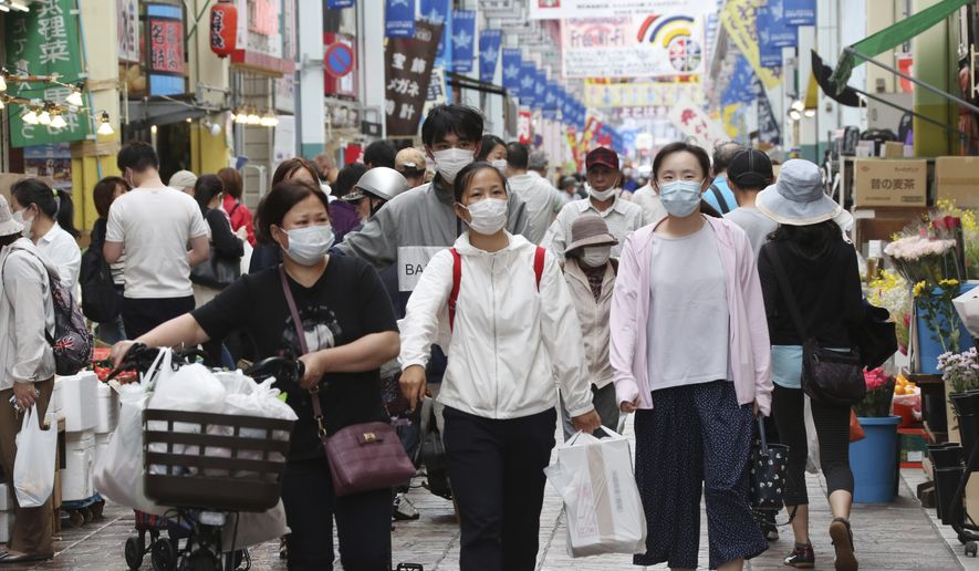 People wearing face masks shop at a mall in Yokohama, near Tokyo, Tuesday, June 23, 2020. Japan’s economy is opening cautiously, with social-distancing restrictions amid the coronavirus pandemic. (AP Photo/Koji Sasahara)