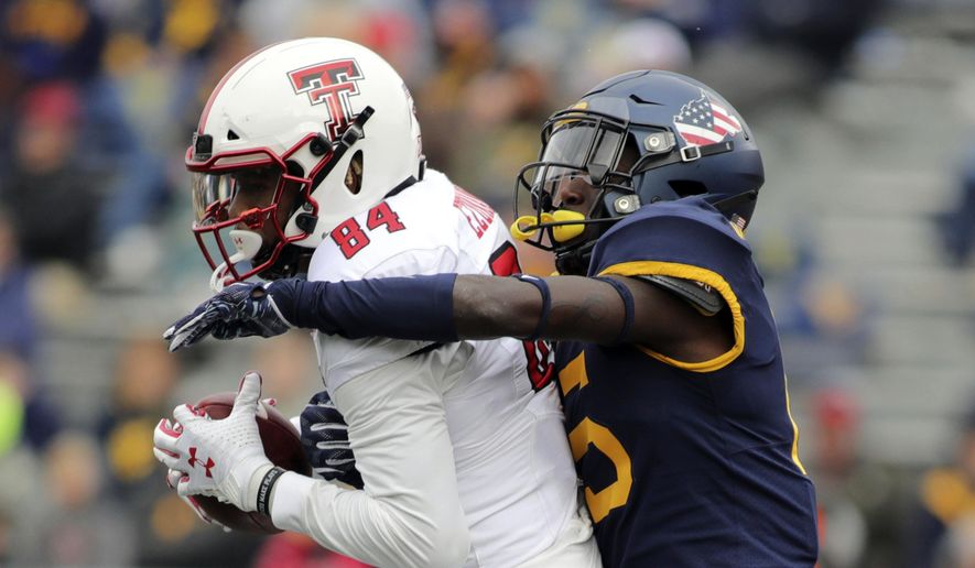 FILE - In this Nov. 9, 2019, file photo, Texas Tech's Erik Ezukanma (84) catches a pass as West Virginia's Kerry Martin (15) defends during the third quarter of an NCAA college football game in Morgantown, W.Va. West Virginia has placed defensive coordinator Vic Koenning on administrative leave after Martin alleged the assistant coach made a series of inappropriate comments. West Virginia athletic director Shane Lyons announced the move Tuesday, June 23, 2020, after Martin posted the allegations on his Twitter account. (AP Photo/Chris Jackson, File)