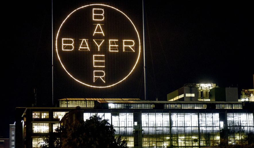 FILE - In this Aug. 9, 2019, file photo, the Bayer logo shines at night at the main chemical plant of German Bayer AG in Leverkusen, Germany. The German pharmaceutical company announced Wednesday, June 24, 2020, it’s paying up to $10.9 billion to settle a lawsuit over subsidiary Monsanto’s weedkiller Roundup, which has faced numerous lawsuits over claims it causes cancer.  (AP Photo/Martin Meissner, File)