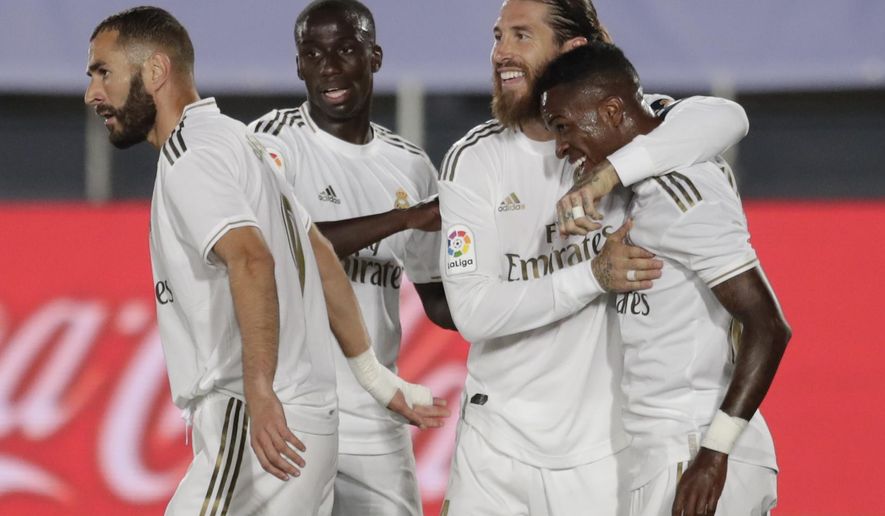 Real Madrid's Vinicius Junior, right, celebrates after scoring the opening goal with teammates during the Spanish La Liga soccer match between Real Madrid and Mallorca at Alfredo di Stefano stadium in Madrid, Spain, Wednesday, June 24, 2020. (AP Photo/Bernat Armangue)