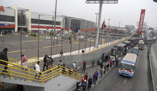 Hundreds of people wait in line outside of at Mega Plaza mall in Lima, Peru, Wednesday, June 24, 2020. Thousands of people crowded in hours-long lines after Peru’s government ignored scientific warnings and opened the country’s 90 shopping malls this week in the middle of one of the world’s worst outbreaks of coronavirus. (AP Photo/Martin Mejia)