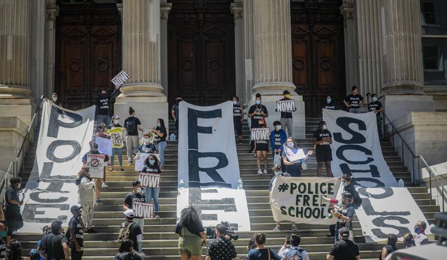 High school students unfurl giant banners on the steps of Tweed Court, during a rally near City Hall calling for 100 percent police-free schools and defunding the NYPD, Thursday June 25, 2020, in New York. The rally is part of a week of action from the Urban Youth Collaborative and coalition of grass roots organizations calling for police-free schools. (AP Photo/Bebeto Matthews)  **FILE**