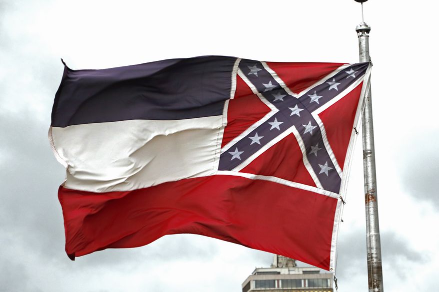 A Mississippi state flag flies outside the Capitol in Jackson, Miss., Thursday, June 25, 2020. Athletic coaches and their staffs from the state's public universities held a joint news conference and called for a change in the Mississippi state flag. Additionally several head coaches met with both the lieutenant governor and Speaker Philip Gunn, as well as their lawmakers, to lobby for the change. The current flag has in the canton portion of the banner the design of the Civil War-era Confederate battle flag, that has been the center of a long-simmering debate about its removal or replacement. (AP Photo/Rogelio V. Solis)