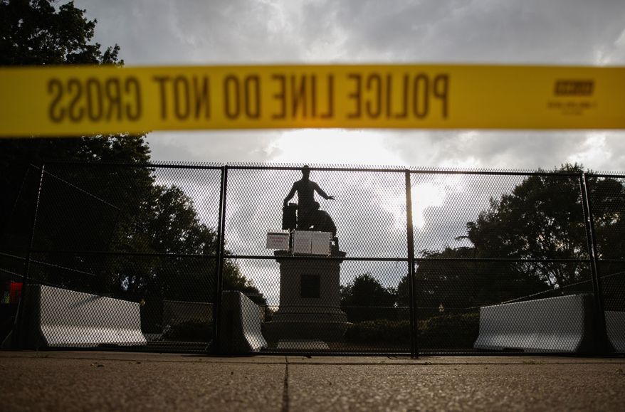 Yellow police tape, concrete barricades and fencing surround the Emancipation Memorial in Lincoln Park in Washington, Thursday, June 25, 2020. The Emancipation Memorial depicts a freed slave kneeling at the feet of President Abraham Lincoln. Calls are intensifying for the removal of the statue as the nation confronts racial injustice. (AP Photo/Carolyn Kaster)