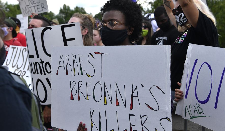 A woman holds up a sign during a rally in memory of Breonna Taylor on the steps of the Kentucky State Capitol in Frankfort, Ky., Thursday, June 25, 2020. The rally was held to demand justice in the death of Taylor who was killed in her apartment by members of the Louisville Metro Police Department on March 13, 2020. (AP Photo/Timothy D. Easley)