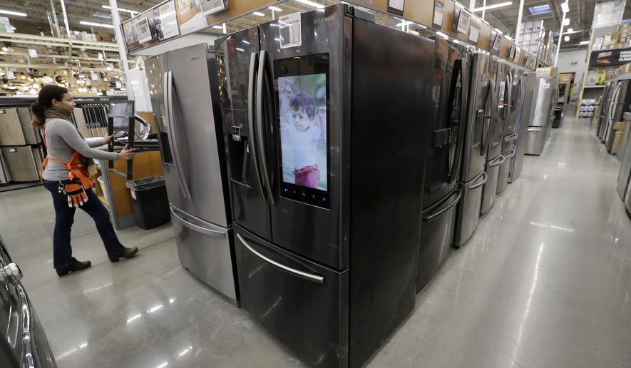 FILE - In this Jan. 27, 2020 file photo a worker pushes a cart past refrigerators at a Home Depot store location in Boston. On Thursday, June 25, orders to American factories for big-ticket goods rebounded last month from a disastrous May as the U.S. economy began to slowly reopen. (AP Photo/Steven Senne)