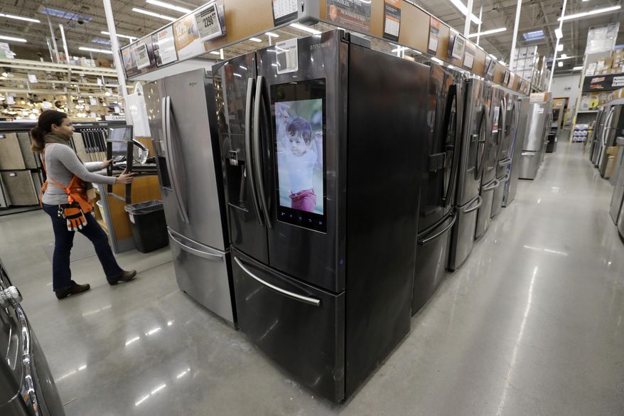 FILE - In this Jan. 27, 2020 file photo a worker pushes a cart past refrigerators at a Home Depot store location in Boston. On Thursday, June 25, orders to American factories for big-ticket goods rebounded last month from a disastrous May as the U.S. economy began to slowly reopen. (AP Photo/Steven Senne)