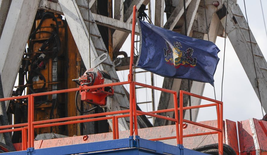 In this file photo from March 12, 2020, the flag of the Commonwealth of Pennsylvania flies on the drilling rig as work continues at a shale gas well drilling site in St. Mary&#x27;s, Pa. (AP Photo/Keith Srakocic, File)  **FILE**