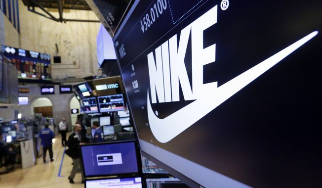In this March 22, 2017, photo, the Nike logo appears above the post where it trades on the floor of the New York Stock Exchange. (AP Photo/Richard Drew) **FILE**