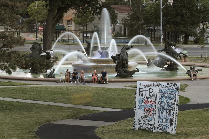In this photo taken Tuesday, June 23, 2020, people gather at the J.C. Nichols fountain in Kansas City, Mo. The city&#39;s board of parks and recreation is considering a proposal to remove the J.C. Nichols name from the fountain and a nearby street as they address racial concerns about the influential local developer. Nichols developed some of the area&#39;s most desirable neighborhoods as well as the city&#39;s County Club Plaza shopping district in the early 1900&#39;s but excluded Blacks, Jews and other minorities using deed restrictions on his properties. (AP Photo/Charlie Riedel)