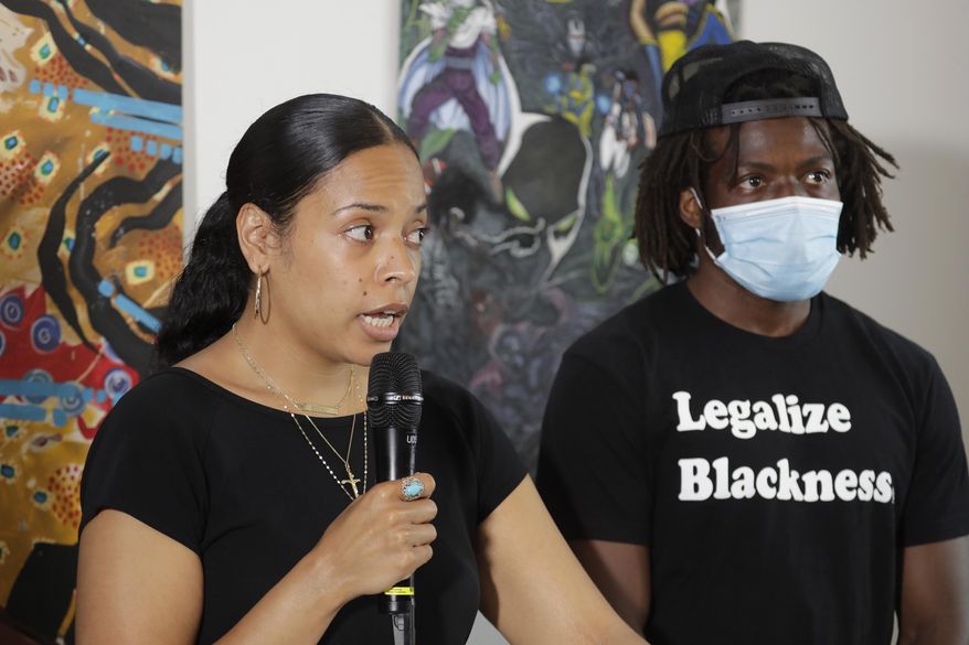 Naudia Miller, left, and Marcus Henderson, right, both of Black Collective Voices, speak Thursday, June 25, 2020, at a news conference in Seattle. Miller said the goal of protesters who have been active in the CHOP (Capitol Hill Occupied Protest) zone and elsewhere in the city since the death of George Floyd in Minneapolis is to dismantle systemic racism and to continue organizing until all of their demands are met. (AP Photo/Ted S. Warren)