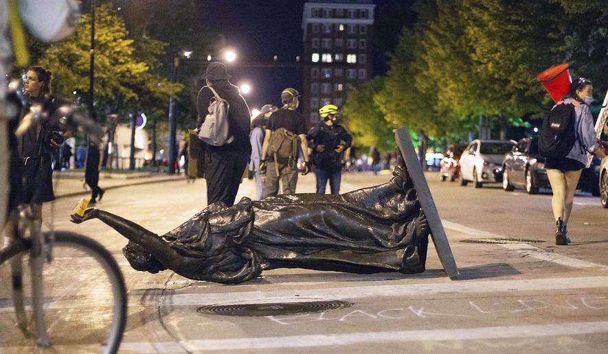 FILE - In this June 23, 2020 file photo, Wisconsin's "Forward" statue lies in the street on Capitol Square in Madison, Wis. Demonstrators who toppled statues this week honoring Hans Christian Heg, a Civil War abolitionist, and the state's "Forward" motto say they went after the sculptures because they wanted to shatter a false narrative that the state and the city support Black people and have achieved racial equity. (Emily Hamer/Wisconsin State Journal via AP File)