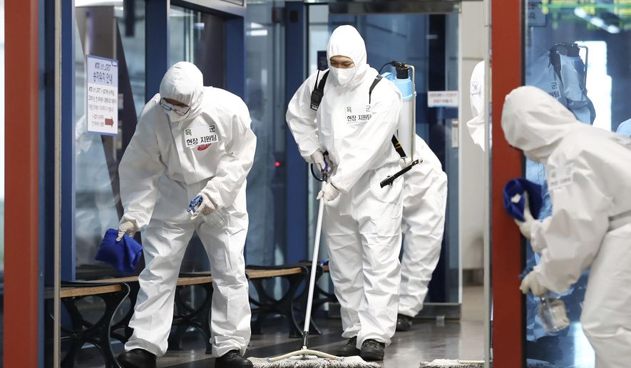 South Korean soldiers wearing protective gears disinfect as a precaution against the new coronavirus at a train station in Daejeon, South Korea, Thursday, June 25, 2020. (Kim Jun-beom/Yonhap via AP)
