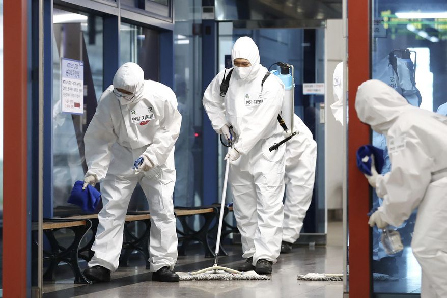 South Korean soldiers wearing protective gears disinfect as a precaution against the new coronavirus at a train station in Daejeon, South Korea, Thursday, June 25, 2020. (Kim Jun-beom/Yonhap via AP)