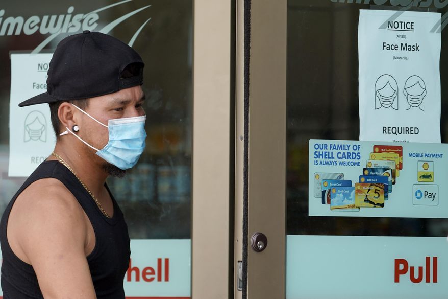 A man enters a convenience store while wearing a required face mask, Thursday, June 25, 2020, in Houston. Texas Gov. Greg Abbott said Wednesday that the state is facing a "massive outbreak" in the coronavirus pandemic and that some new local restrictions may be needed to protect hospital space for new patients. (AP Photo/David J. Phillip)