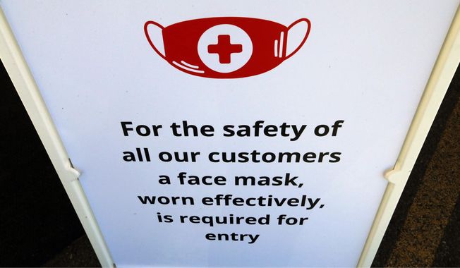 In this Tuesday, June 23, 2020, photo, a "Face Covering" sign is shown at Snider Bros. Meats, in Holladay, Utah. (AP Photo/Rick Bowmer)