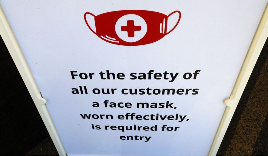 In this Tuesday, June 23, 2020, photo, a "Face Covering" sign is shown at Snider Bros. Meats, in Holladay, Utah. (AP Photo/Rick Bowmer)