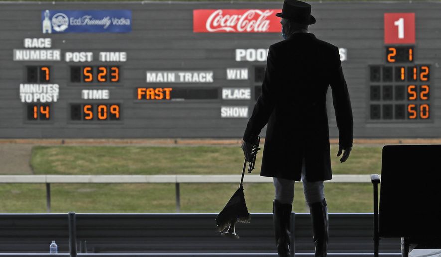 Track bugler Dan Harrington stands near empty seats Wednesday, June 24, 2020, before playing just before a race at Emerald Downs Racetrack in Auburn, Wash., on the first day of thoroughbred horse racing at the track since all professional sports in Washington state were curtailed in March by the outbreak of the coronavirus. No spectators were allowed, but online wagering was available and the races were streamed. Organizers hope to continue racing into October on a modified schedule. (AP Photo/Ted S. Warren)
