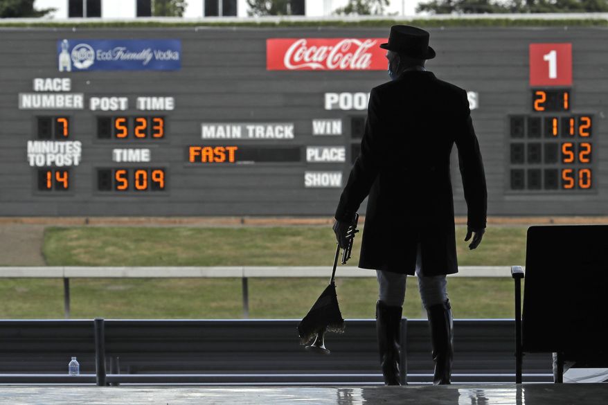 Track bugler Dan Harrington stands near empty seats Wednesday, June 24, 2020, before playing just before a race at Emerald Downs Racetrack in Auburn, Wash., on the first day of thoroughbred horse racing at the track since all professional sports in Washington state were curtailed in March by the outbreak of the coronavirus. No spectators were allowed, but online wagering was available and the races were streamed. Organizers hope to continue racing into October on a modified schedule. (AP Photo/Ted S. Warren)