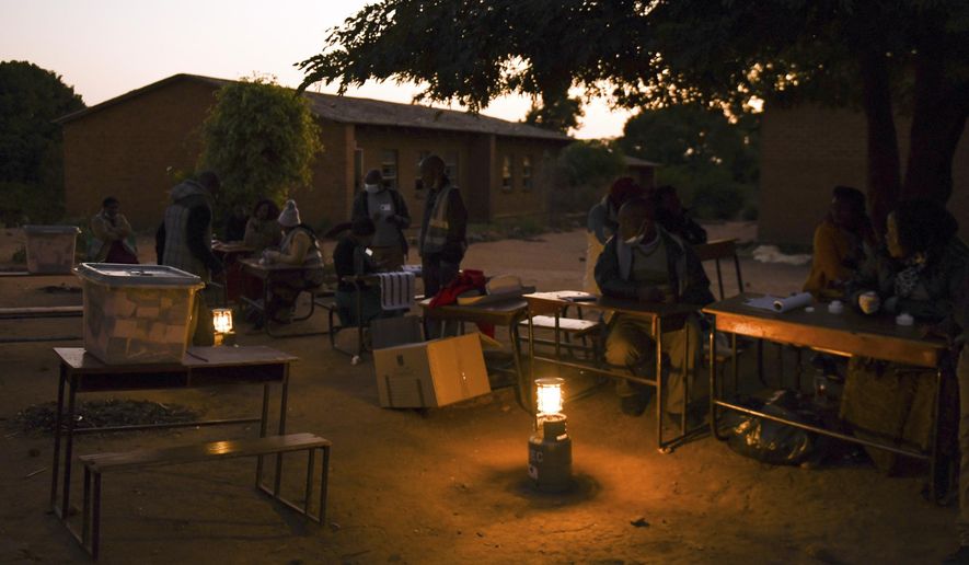 Voting station officials prepare lighting to count votes the end of a days voting at a polling station in Blantyre, Malawi Tuesday, June 23 2020. The country returned to the polls to elect a president, after the courts nullified the results of the election held more than a year ago. (AP Photo/Thoko Chikondi)