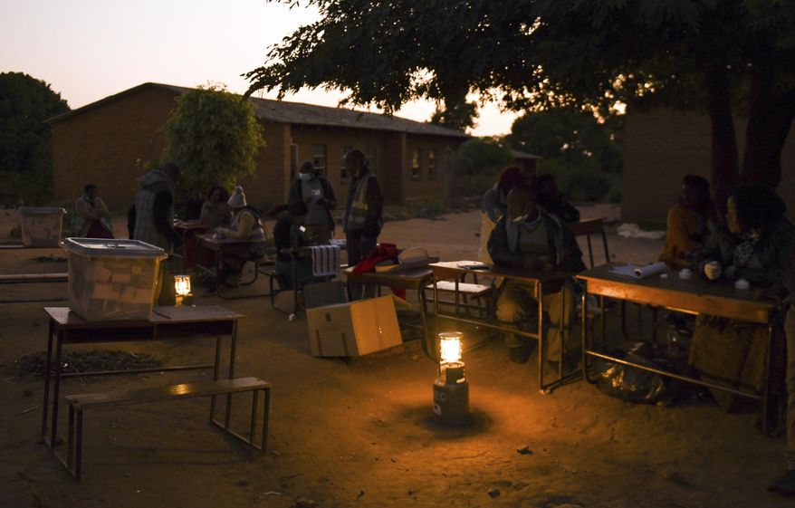 Voting station officials prepare lighting to count votes the end of a days voting at a polling station in Blantyre, Malawi Tuesday, June 23 2020. The country returned to the polls to elect a president, after the courts nullified the results of the election held more than a year ago. (AP Photo/Thoko Chikondi)