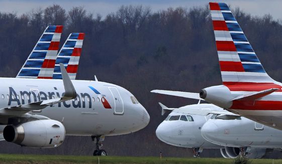In this March 31, 2020, file photo, American Airlines planes are parked at Pittsburgh International Airport in Imperial, Pa.  There will be no more attempts at social distancing on American Airlines flights. The airline said Friday, June 26,  that it will start booking flights to full capacity next week. (AP Photo/Gene J. Puskar, file) ** FILE **