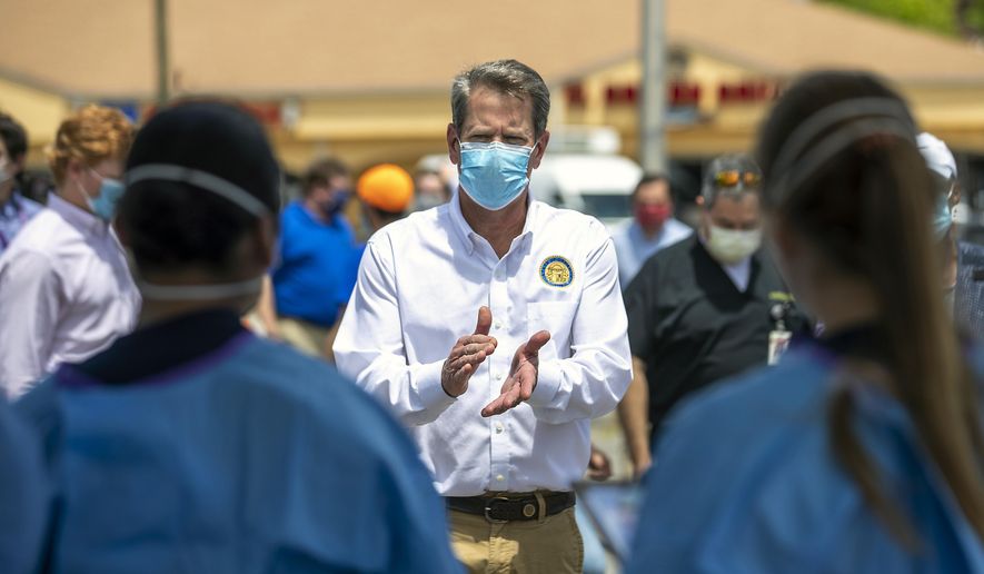 Georgia Governor Brian Kemp applauds healthcare workers for their service while touring a community COVID-19 testing site in the parking lot of La Flor de Jalisco #2 during a visit to Gainesville, Ga., Friday, May 15, 2020. (Alyssa Pointer/Atlanta Journal-Constitution via AP)