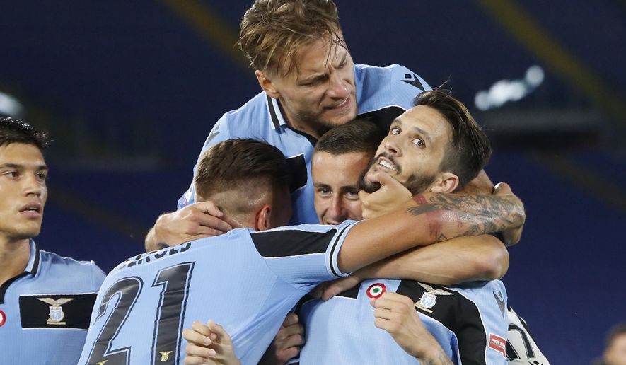 Lazio's Luis Alberto, right, celebrates with his teammates Sergej Milinkovic-Savic,Adam Marusic and Ciro Immobile, on top, after scoring his side's second goal during a Serie A soccer match between Lazio and Fiorentina at Rome's Olympic stadium, Saturday, June 27, 2020. (AP Photo/Riccardo de Luca)