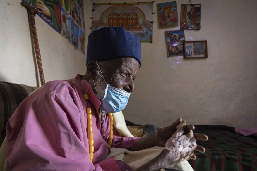 Centenarian Tilahun Woldemichael crys as he prays to God after spending weeks in hospital recovering from the coronavirus, at his house in Addis Ababa, Ethiopia Saturday, June 27, 2020. The Ethiopian monk believed to be 114 years old has survived the coronavirus and was discharged from a hospital on Thursday, having received oxygen and dexamethasone, a cheap and widely available steroid that researchers in England have said reduced deaths by up to one third in severely ill hospitalized patients. (AP Photo/Mulugeta Ayene)