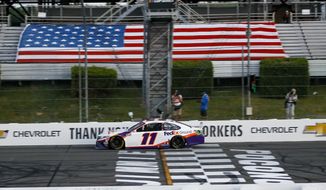 Denny Hamlin gets the checkered flag as he crosses the finish line to win the NASCAR Cup Series auto race at Pocono Raceway, Sunday, June 28, 2020, in Long Pond, Pa. (AP Photo/Matt Slocum)