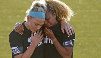 Chicago Red Stars&#39; Julie Ertz, left, holds Casey Short after players for their team knelt during the national anthem before an NWSL Challenge Cup soccer match against the Washington Spirit at Zions Bank Stadium, Saturday, June 27, 2020, in Herriman, Utah. (AP Photo/Rick Bowmer)