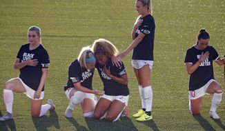 Chicago Red Stars&#39; Julie Ertz, second from left, holds Casey Short, center, while other players for the team kneel during the national anthem before an NWSL Challenge Cup soccer match against the Washington Spirit at Zions Bank Stadium, Saturday, June 27, 2020, in Herriman, Utah. (AP Photo/Rick Bowmer)