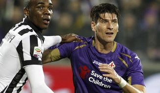 FILE - In a Friday Dec. 5 2014 file photo, Fiorentina&#39;s Mario Gómez and Juventu&#39; Angelo Ogbonna hold each other during a Serie A soccer match at the Artemio Franchi stadium in Florence, Italy. Former Germany striker Mario Gómez has retired from soccer after scoring in his last game for Stuttgart. The soon-to-be 35-year-old says he has fulfilled his final wish – to help Stuttgart secure an immediate return to the Bundesliga after one season in the second division.(AP Photo/Fabrizio Giovannozzi, File)