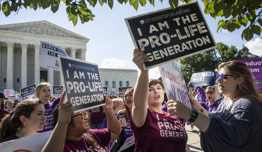 In this file photo, Pro-life and anti-abortion advocates demonstrate in front of the Supreme Court early Monday, June 25, 2018. The justices are expected to hand down decisions today as the court&#x27;s term comes to a close. (AP Photo/J. Scott Applewhite)