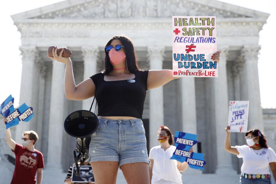 Terrisa Bukovinac, founder of Pro-Life San Francisco, holds a model of a fetus as she and other anti-abortion protesters wait outside the Supreme Court for a decision, Monday, June 29, 2020. The Supreme Court has struck down a Louisiana law regulating abortion clinics, reasserting a commitment to abortion rights over fierce opposition from dissenting conservative justices in the first big abortion case of the Trump era. (AP Photo/Patrick Semansky) **FILE**