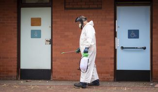 A worker for Leicester City Council disinfects public toilets in Leicester, England, Monday June 29, 2020. The central England city of Leicester is waiting to find out if lockdown restrictions will be extended as a result of a spike in coronavirus infections. (Joe Giddens/PA via AP)
