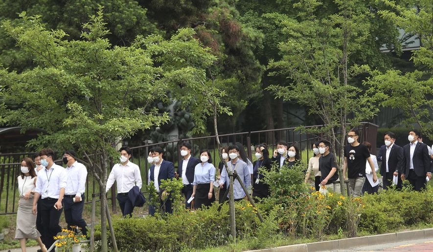 People wearing face masks to help protect against the spread of the new coronavirus cross a road in Seoul, Monday, June 29, 2020. (AP Photo/Ahn Young-joon)