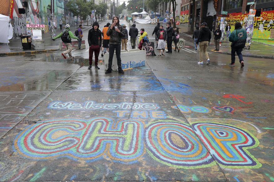 A sign on the street reads &amp;quot;Welcome to the CHOP&amp;quot; as protesters stand near barricades, Tuesday, June 30, 2020 at the CHOP (Capitol Hill Occupied Protest) zone in Seattle. Seattle Department of Transportation workers removed barricades about a block away Tuesday at the intersection of 10th Ave. and Pine St., but protesters quickly moved couches, trash cans and other materials in to replace the cleared barricades. The area has been occupied by protesters since Seattle Police pulled back from their East Precinct building following violent clashes with demonstrators earlier in the month. (AP Photo/Ted S. Warren)