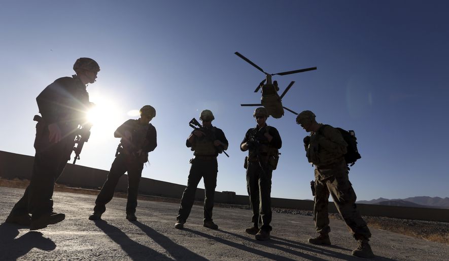 In this Nov. 30, 2017, file photo, American soldiers wait on the tarmac in Logar province, Afghanistan. Top officials in the White House were aware in early 2019 of classified intelligence indicating Russia was secretly offering bounties to the Taliban for the deaths of Americans, a full year earlier than has been previously reported. (AP Photo/Rahmat Gul, File)