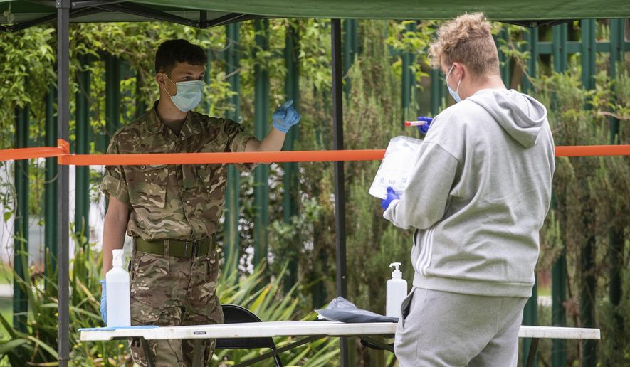 Members of the military operate a walk-in mobile Covid-19 testing centre at Spinney Hill Park in Leicester, England, Monday June 29, 2020. The British government is reimposing lockdown restrictions in the central England city of Leicester after a spike in coronavirus infections, including the closure of shops that don’t sell essential goods and schools.  (Joe Giddens/PA via AP)