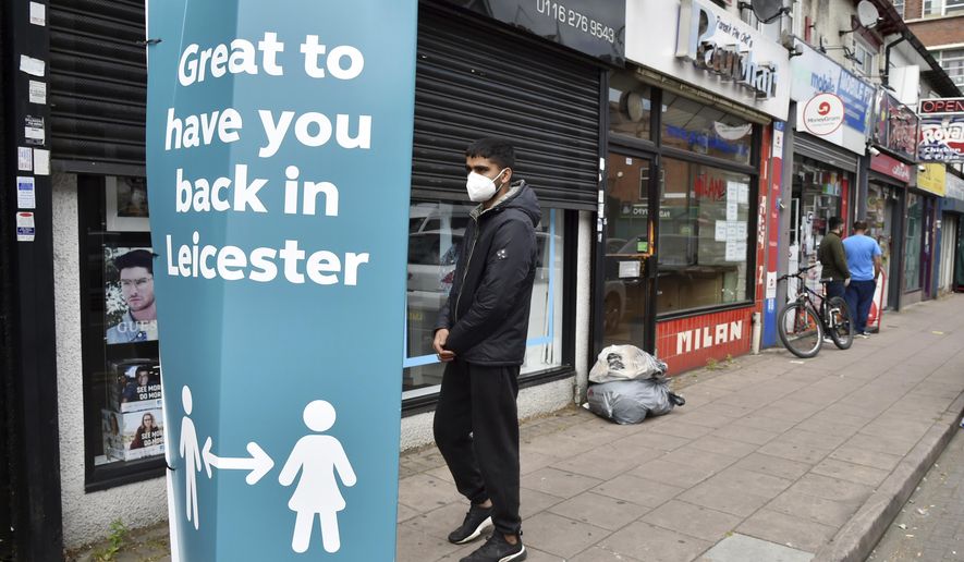 People walk past closed shops in Leicester, England, Tuesday June 30, 2020. The British government has reimposed lockdown restrictions in the English city of Leicester after a spike in coronavirus infections, including the closure of shops that don&#x27;t sell essential goods and schools. (AP Photo/Rui Vieira)