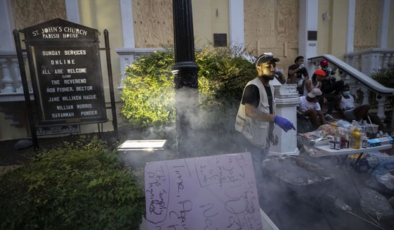 People set up tables and provide free food and drinks on the sidewalk in front of St. John&#39;s Church as demonstrators protest Thursday, June 4, 2020, near the White House in Washington, over the death of George Floyd, a black man who was in police custody in Minneapolis. Floyd died after being restrained by Minneapolis police officers. (AP Photo/Alex Brandon)