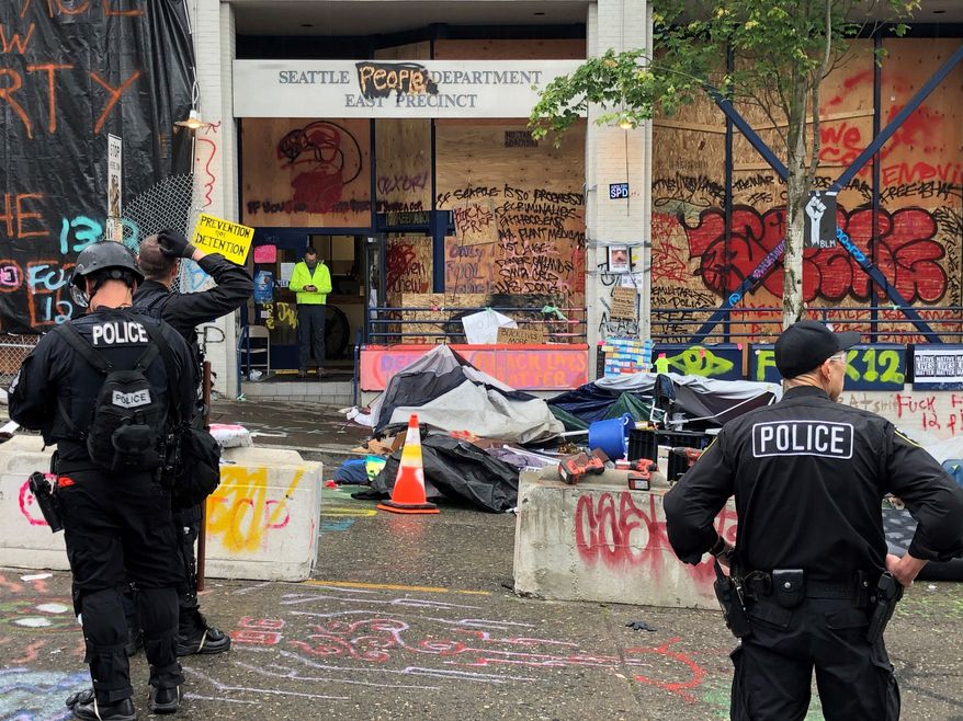 Seattle police enter the East Precinct in Seattle on Wednesday, July 1 2020 after clearing out the CHOP zone.  (Steve Ringman/The Seattle Times via AP)