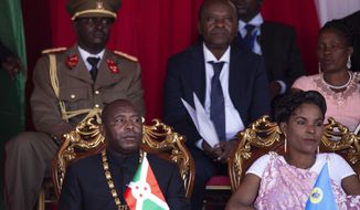 Burundi&#39;s President Evariste Ndayishimiye, left, and his wife Angeline Ndayubaha, right, attend his inauguration in Gitega, Burundi, Thursday, June 18, 2020. President Evariste Ndayishimiye took power two months early after the abrupt death of his predecessor Pierre Nkurunziza. (AP Photo/Berthier Mugiraneza)